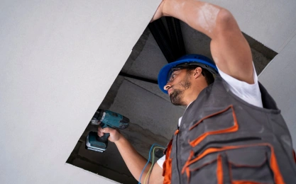 AC Technician working on unit in the ceiling